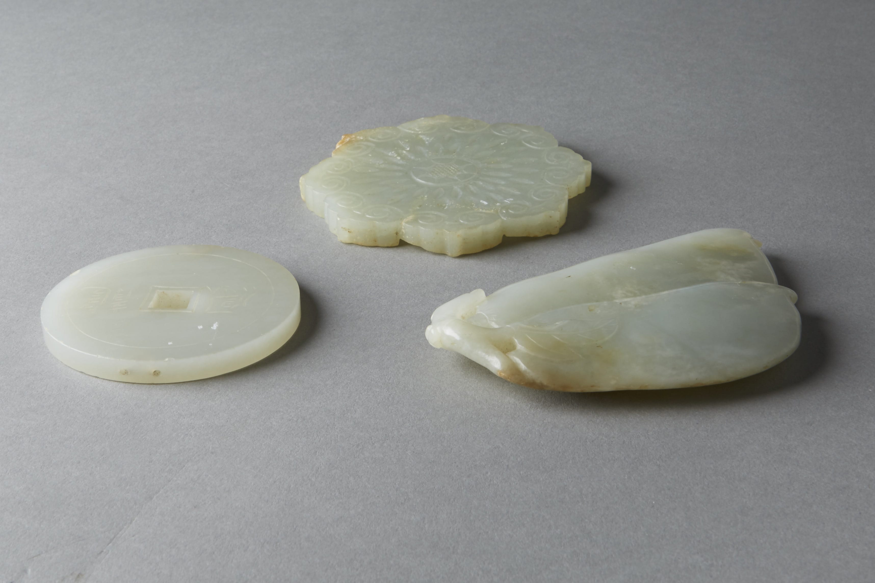 Lot 015: Group of 3: Chinese 19th century Celadon Jade Pendants with Carvings Coin Button Bean Pod