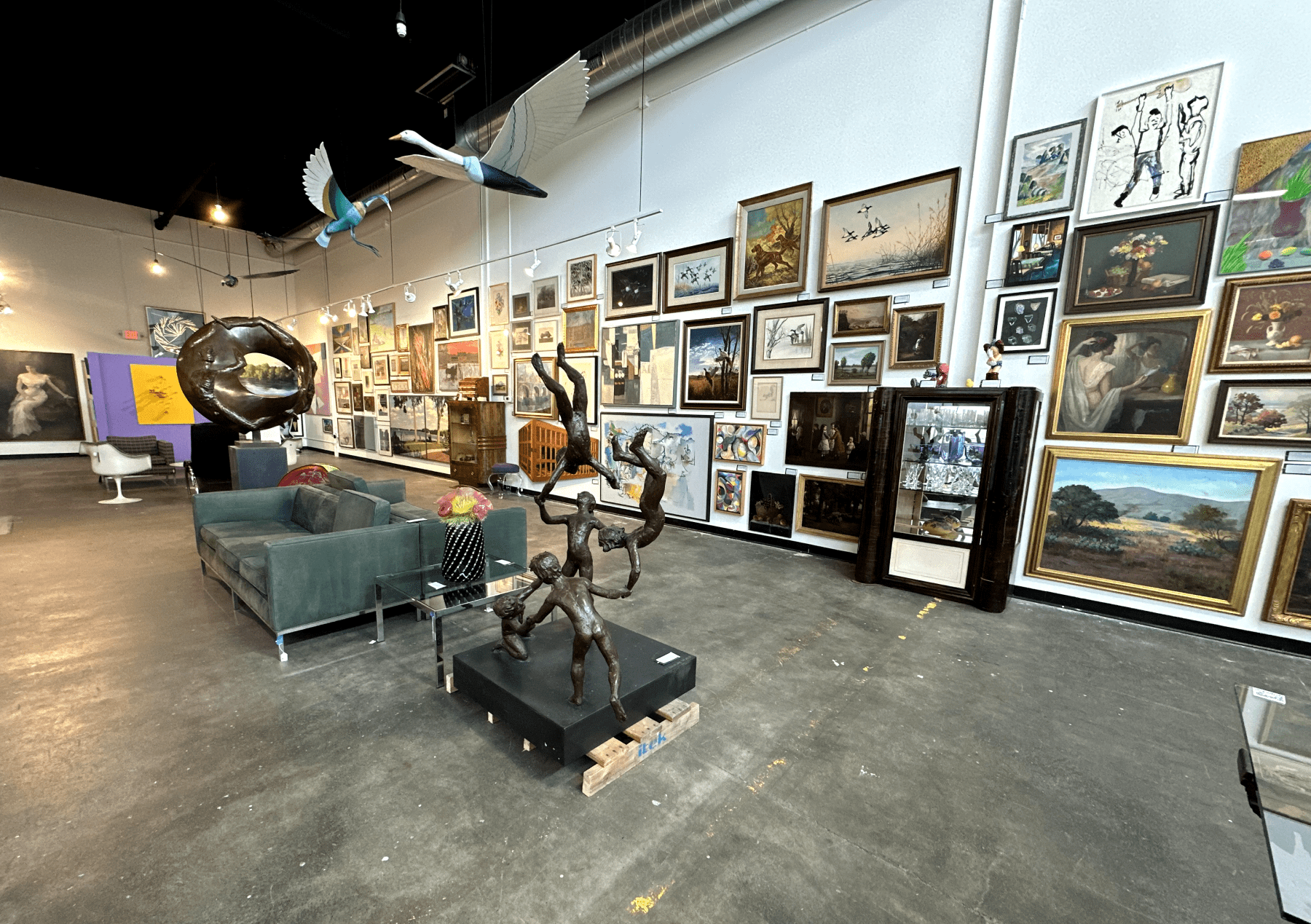 Auction gallery hung with framed paintings and sculpture