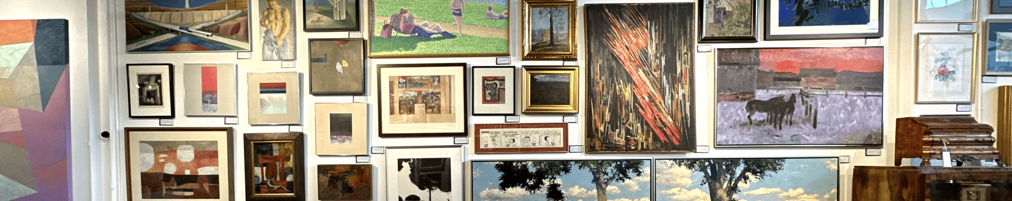 Salon-style gallery wall of framed fine-art paintings