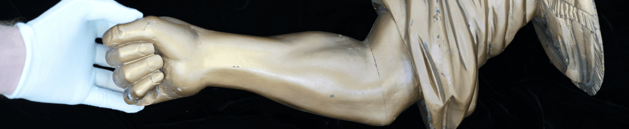 Conservator's gloved hands handling a sculpture during restoration